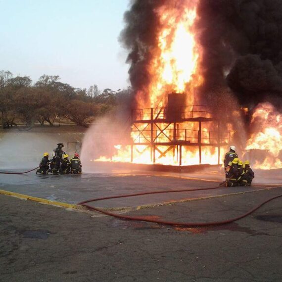 Firefighters attacking a live fuel fire during a practical training exercise