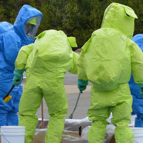 Trainees in fully encapsulated hazmat suits during a decontamination exercise