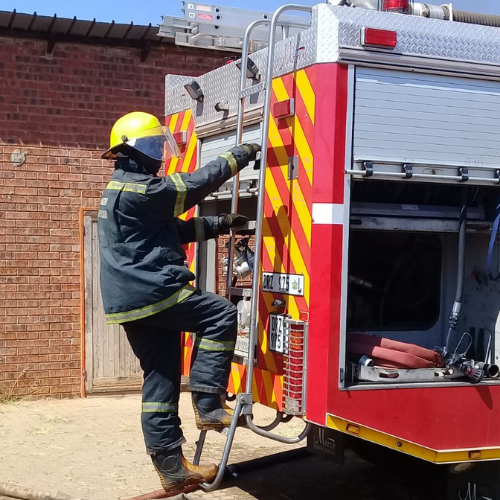 Firefighter climbing the ladder on the rear of a fire engine