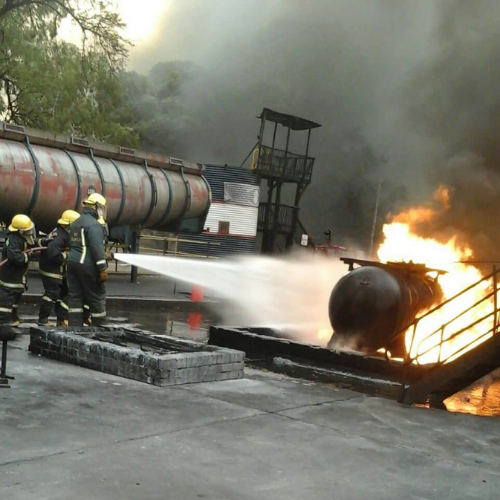 Firefighters cooling a burning fuel tanker during a large-scale exercise