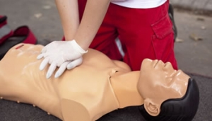 Learner performing chest compressions on a CPR training manikin