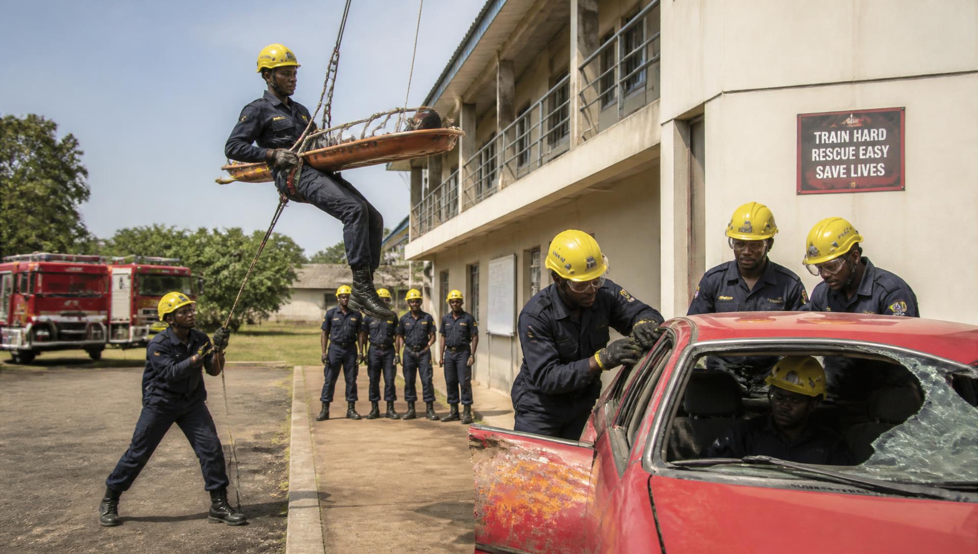 Trainee firefighters practising rope rescue and vehicle extrication at a training academy